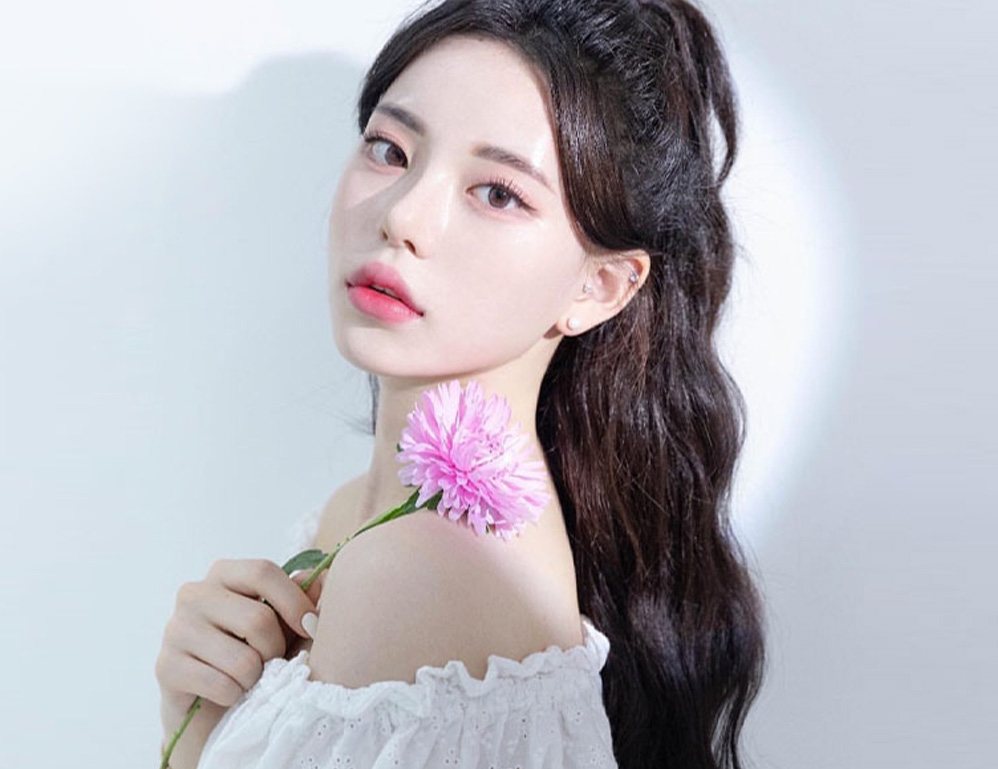 분홍 꽃을 든 웨이브 머리 여성 모델