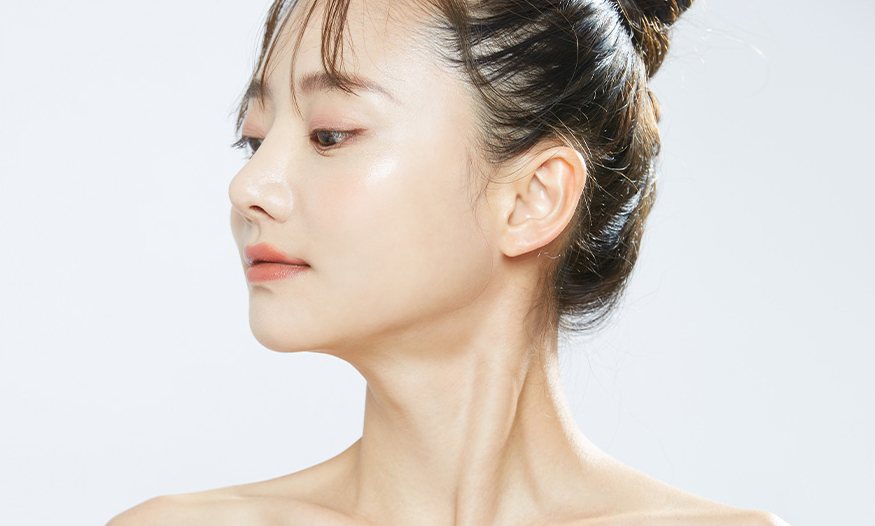 연하늘 회색 바탕 앞 올림머리 여성 모델의 3/4 옆얼굴(코 옆선)